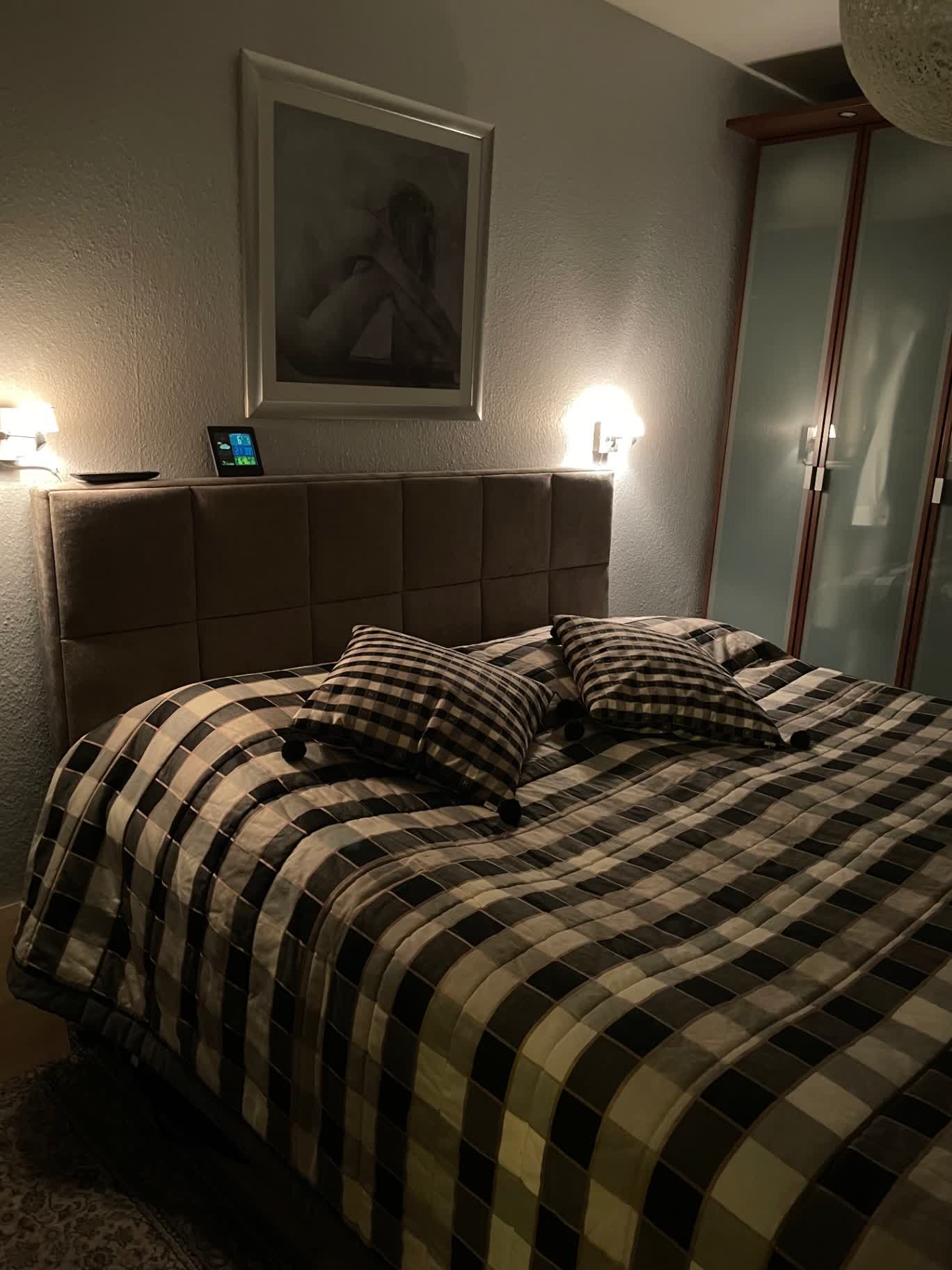 Kundeoplevelse med seng i mørkt soveværelse og sengetøj